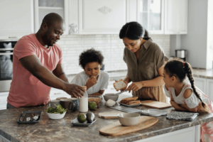 A family making a meal together in a kitchen.  creating-a-welcoming-home-the-power-of-odor-control-with-number-2-perfume/